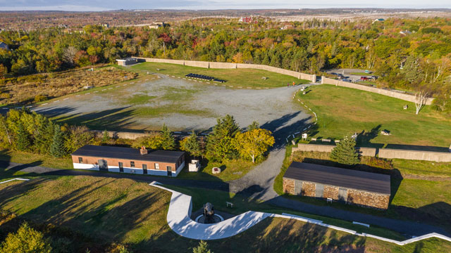 There is a large parking lot inside the gates made of gravel and grass.