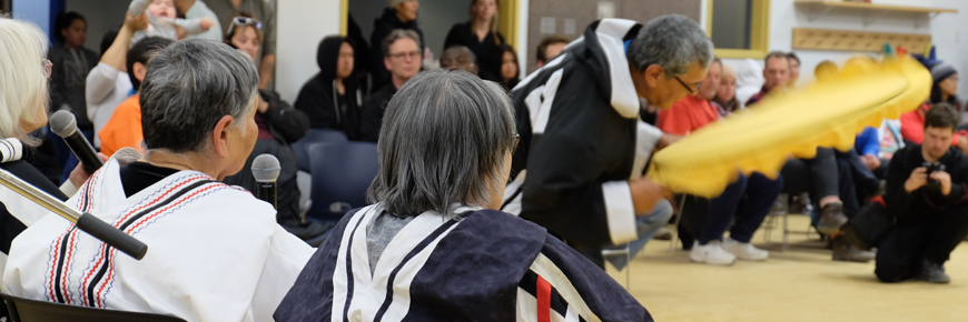 A drum dancer performing for an audience.