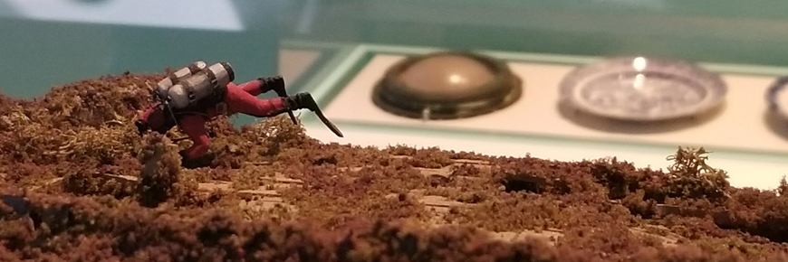 A diorama of scuba diver at a shipwreck.