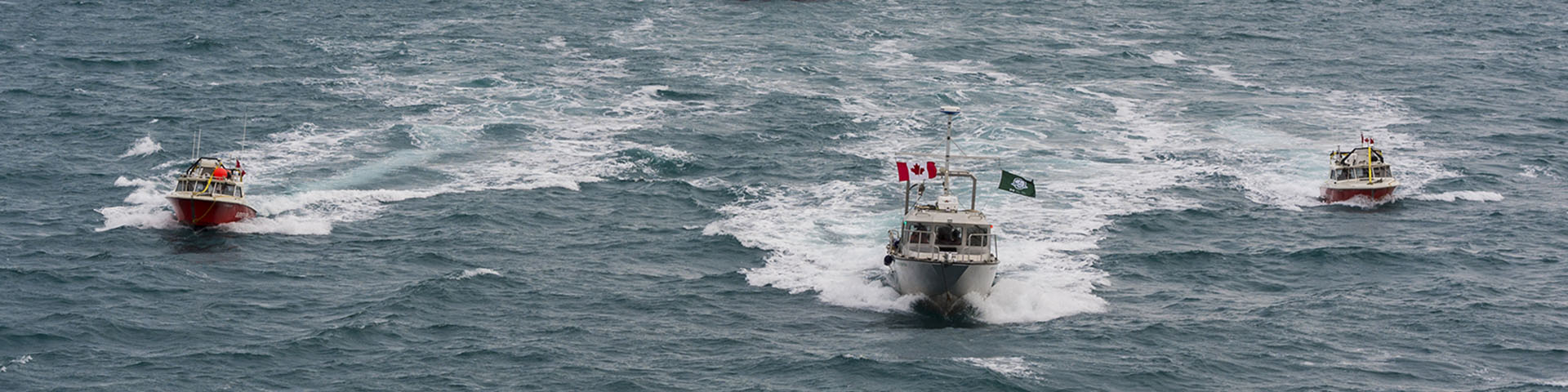 Trois bateaux se déplaçant sur l'eau. 