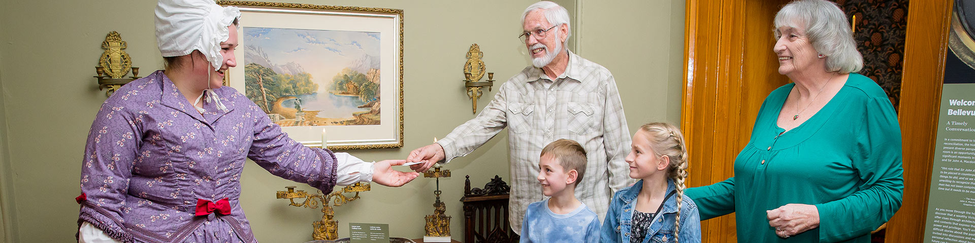 A family interacts with a costumed staff member.