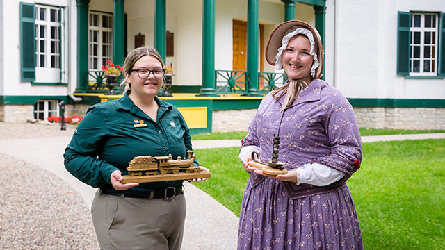 Deux employés devant une maison historique.