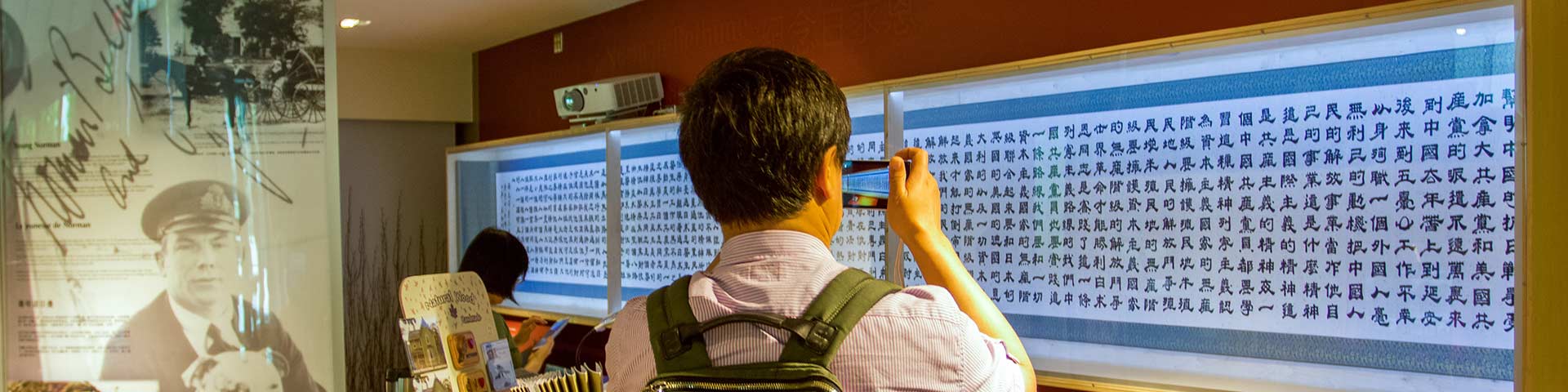 A visitor takes a photo of artwork.