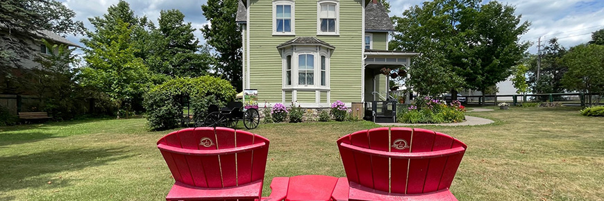 Des chaises rouges et une maison historique.