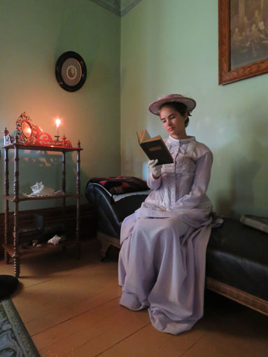 A women in historic clothing reading a book
