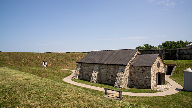 3 people walk towards the Powder Magazine