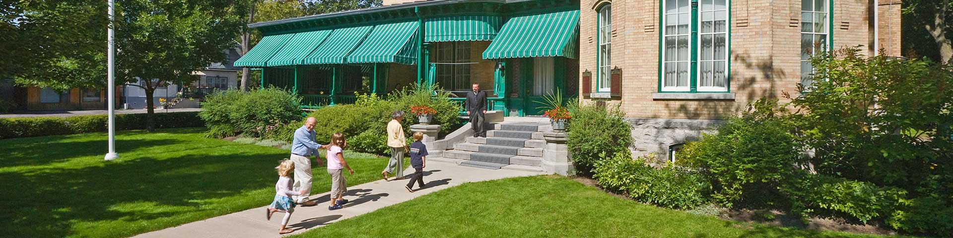 A family walks up to a historic house.