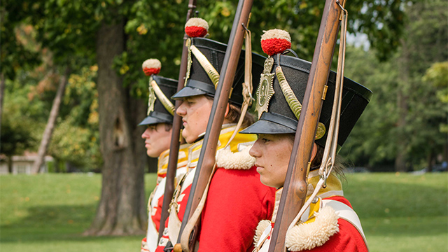 Trois présentateurs du patrimoine en tenue historique de soldat de la rébellion du Haut-Canada