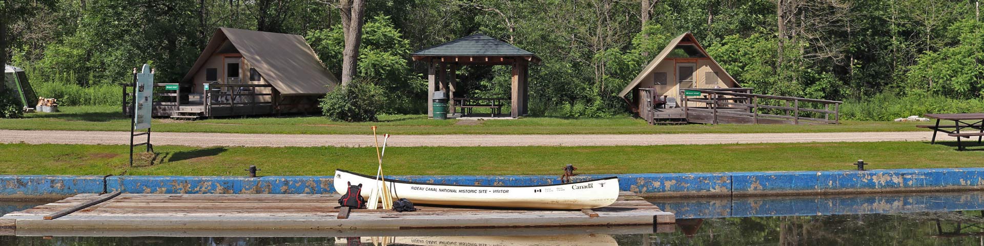 Des pagayeurs sur un quai du canal Rideau s’apprêtent à monter à bord de leur embarcation.