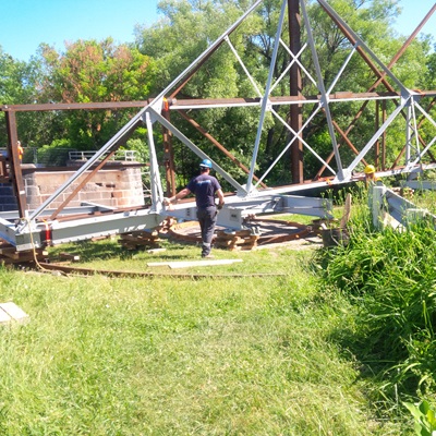 Portion of the newly repaired bridge lifted into place by crane