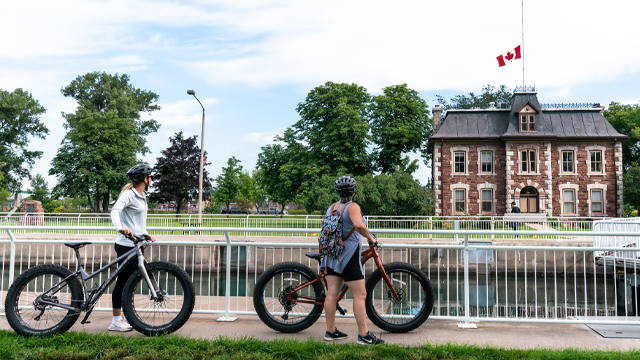 Two friends with bikes looking at the canal.