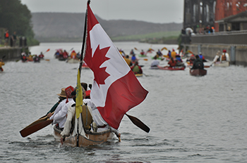 A canoe flying a Canadian flag
