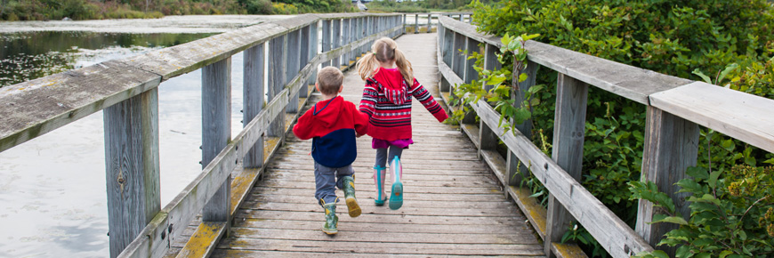 Deux enfants qui courent sur une promenade.