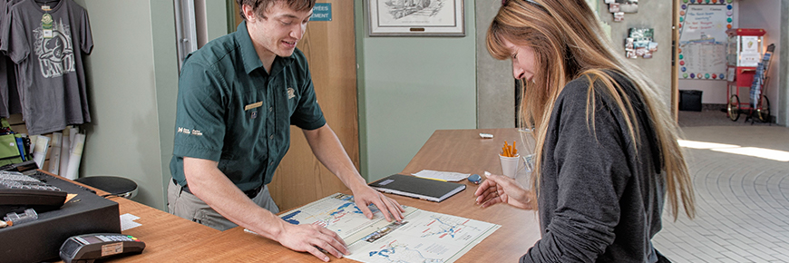 A Parks Canada team member assists a visitor at a Visitor Information Centre.