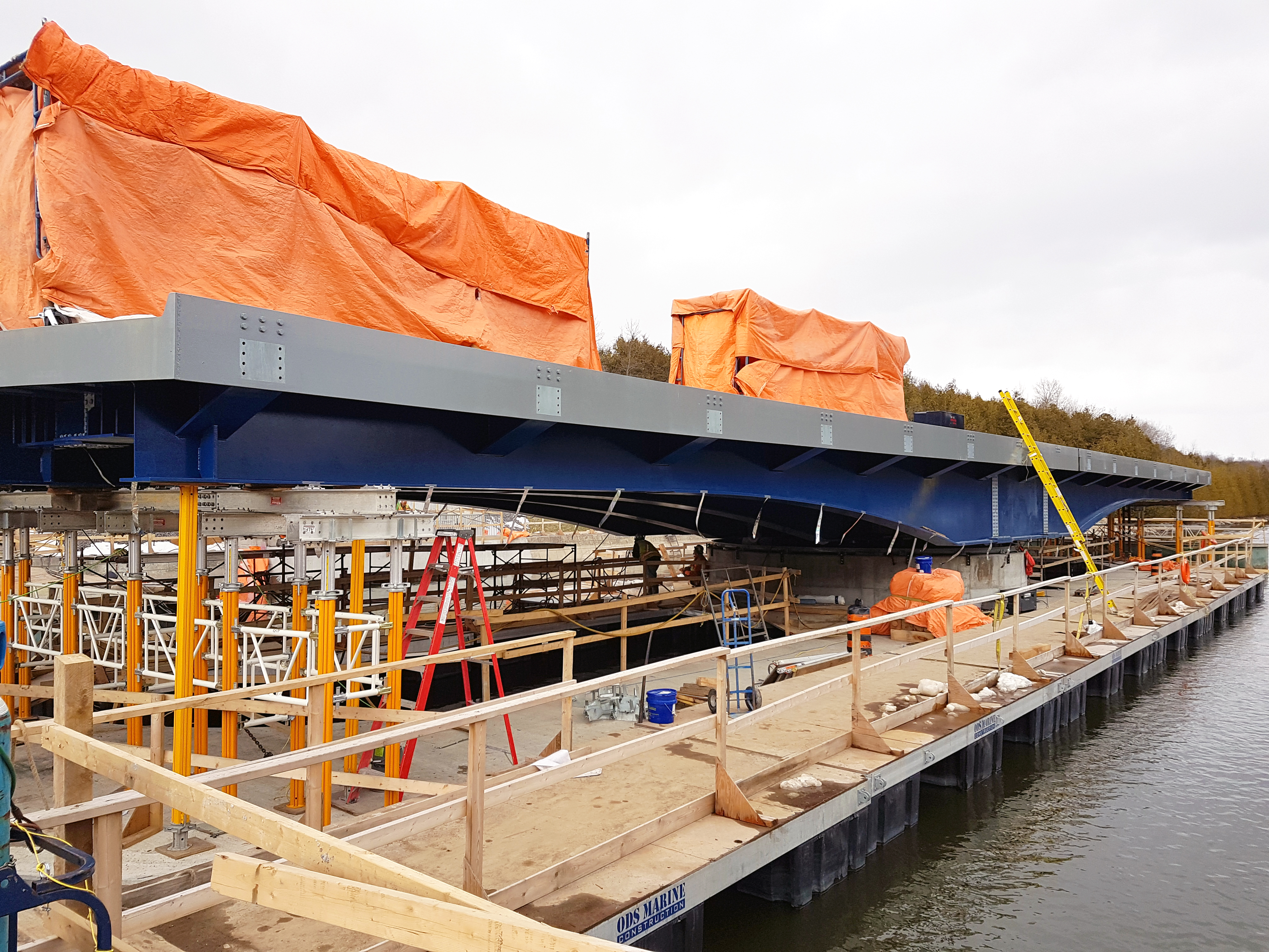 A blue and grey bridge on a construction site.