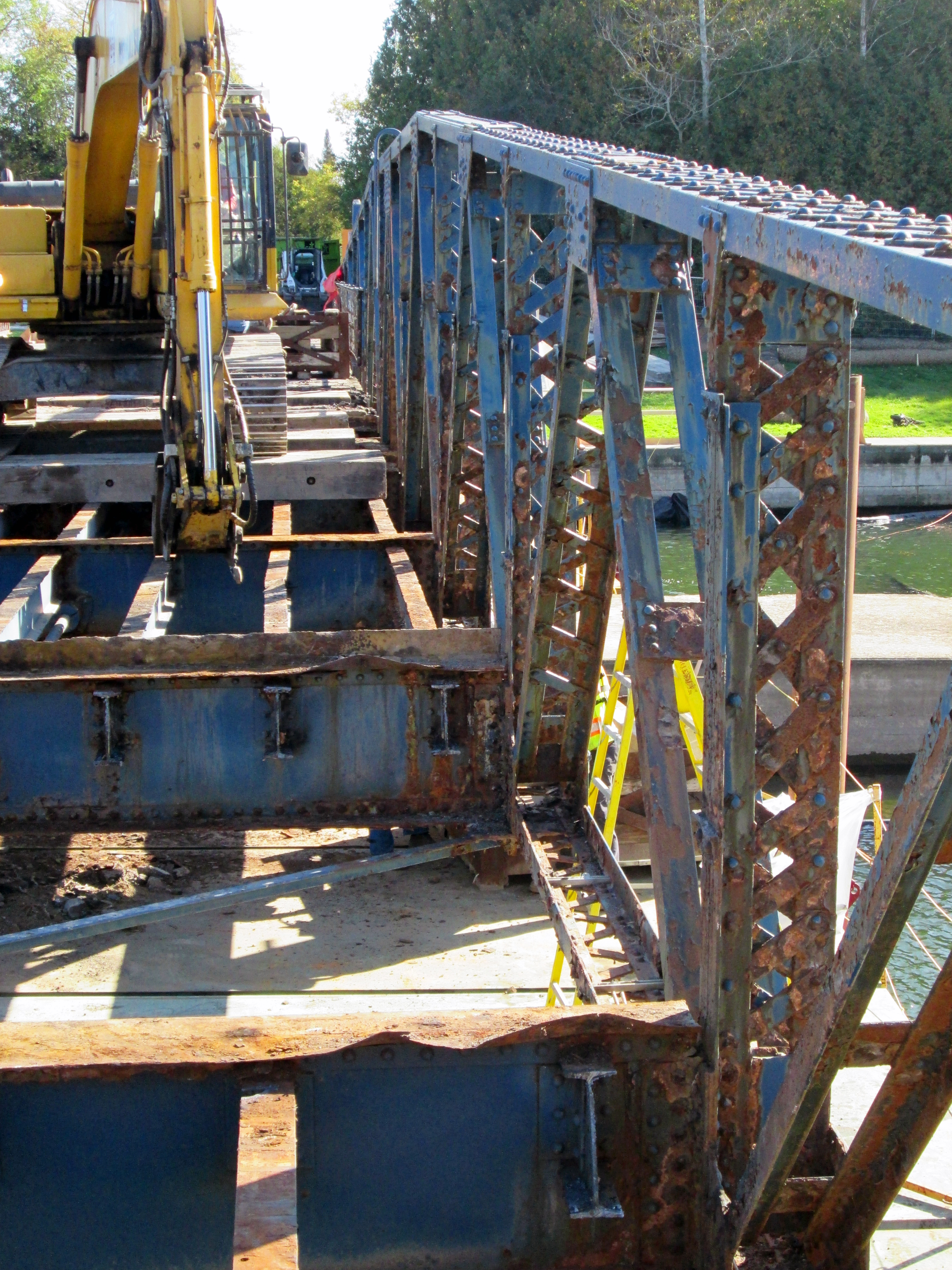 Machinery sits on a portion of the Brighton Road Bridge and removes roadway decking from adjacent parts of the bridge.