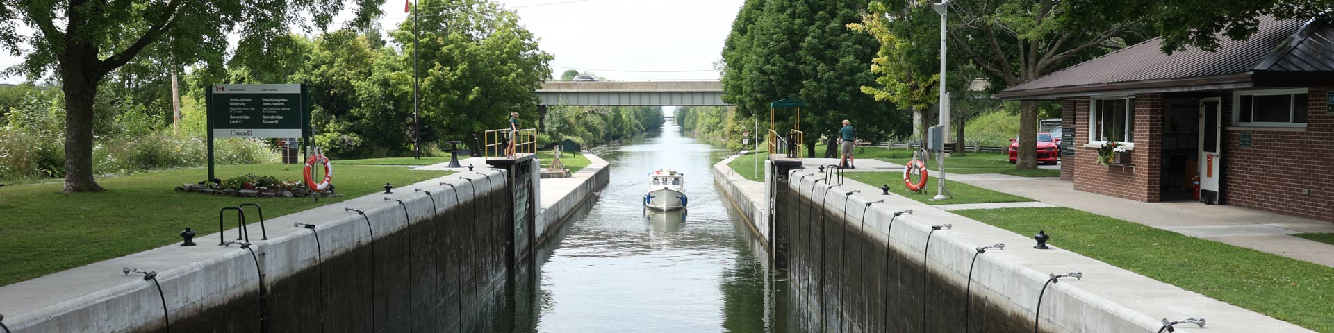 boat approaches a lockstation with canal in background