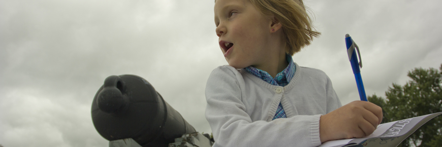 A child fills out her explorers booklet. 