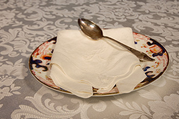 Cloth napkin on plate with tea spoon