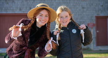 Anne with a young girl hold their red haired braids