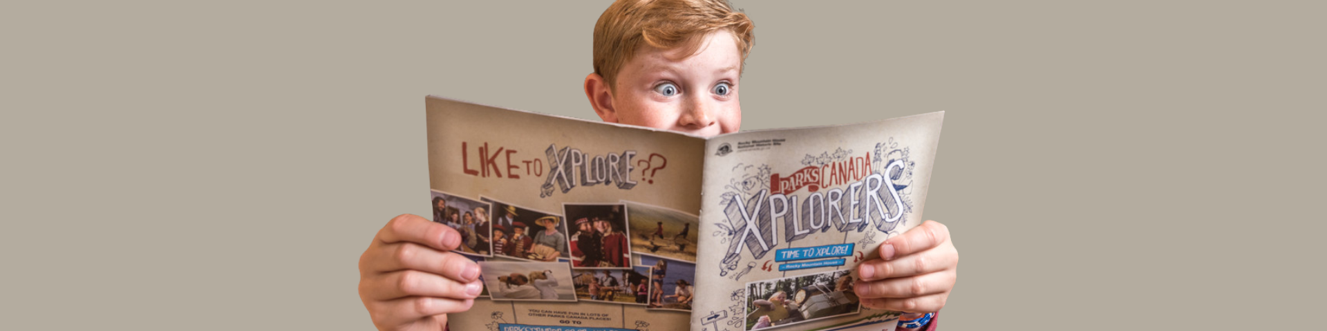An image of a young child holding an Xplorers activity book 