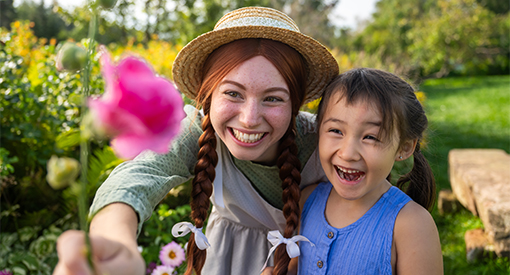 Anne partage une fleur rose avec une jeune fille