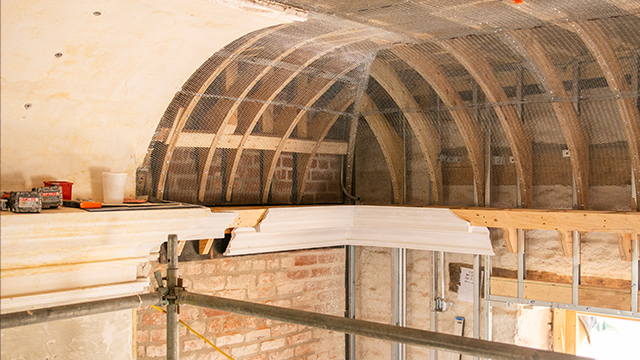 Arched wooded beams are exposed on a tall ceiling