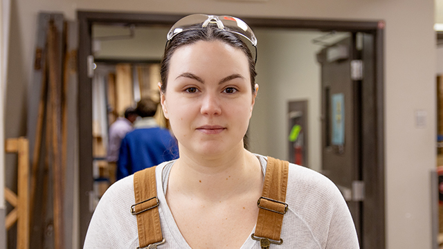 Melinda Burke, student at Holland College, stands in the doorway of a wood workshop.