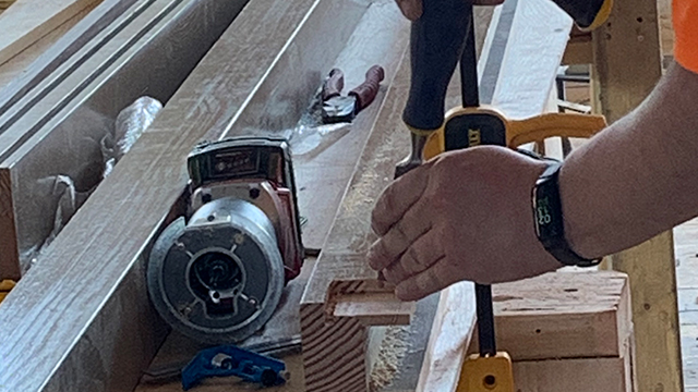 Close up of hands working with a piece of wooden trim 
