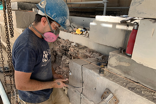 Maçon travaillant à la reconstruction de la pierre. 