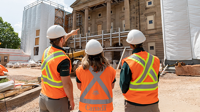 Three park staff are looking at Province House under construction