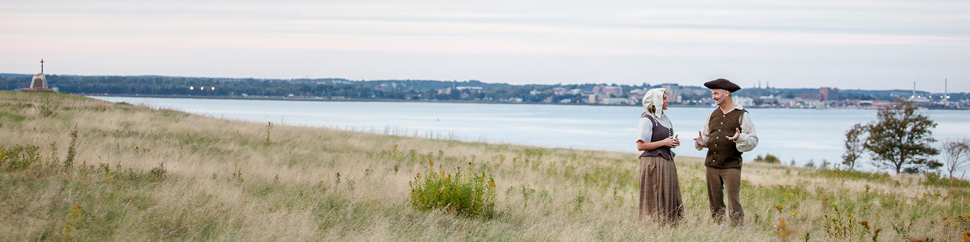 Animators dressed as Acadian settlers re-enact historical times on a hill with a view overlooking the mouth of the Hillsborough River. Skmaqn–Port-la-Joye–Fort Amherst National Historic Site.