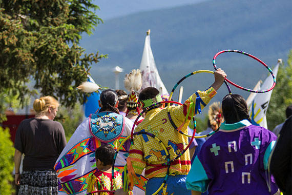 Hoop dancer among a group of participants in traditional regalia at National Aboriginal Day, Jasper National Park.