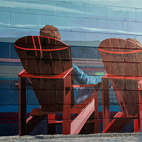 Mural of red chairs painted on a building near the Lachine Canal