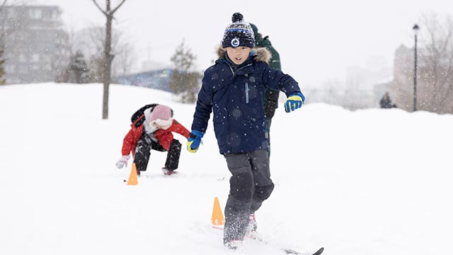 Un jeune garçon utilise pour la première fois des skis de fond sur de la neige fraîche.