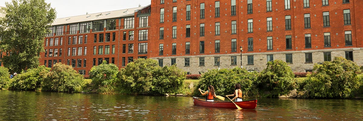 2 women paddling in the calm waters of the Lachine Canal