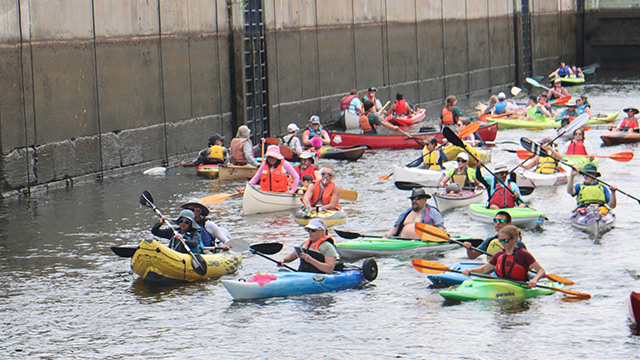 Des kayakistes franchissent une écluse ensemble lors d’une activité nautique.