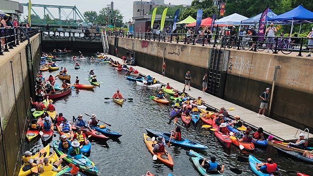 Group of people in their kayak on the water in a canal in summer.