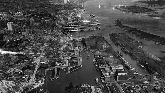 Aerial view of a port and canal entrance in the mid-20th century.