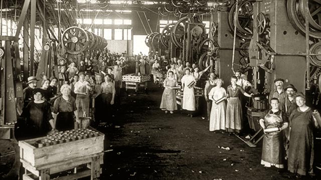 Female workers from the early 20th century, during the industrial era, take the time to pose for the photographer.