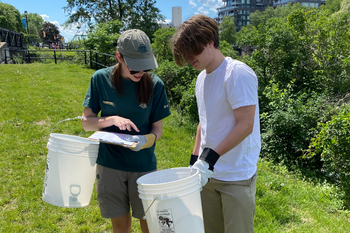 A Parks Canada employee is helping a volunteer to check his list of what he picked up