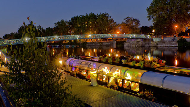 Illuminated boat docked at the Lachine Canal in the evening 