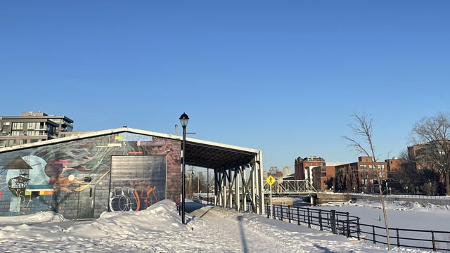 A graffiti-painted building beside a canal on a winter's day.