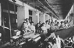 Workers (men, women and children) behind some machines