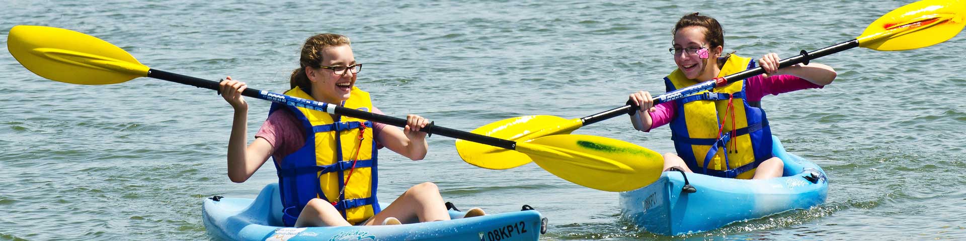 2 enfants et un employé de Parcs Canada en canot sur le canal.