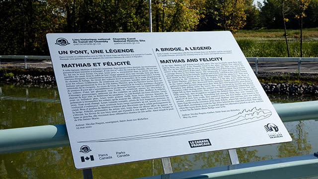 Bilingual sign reading “Un pont, une légende / A Bridge, a Legend” at the Chambly Canal.
