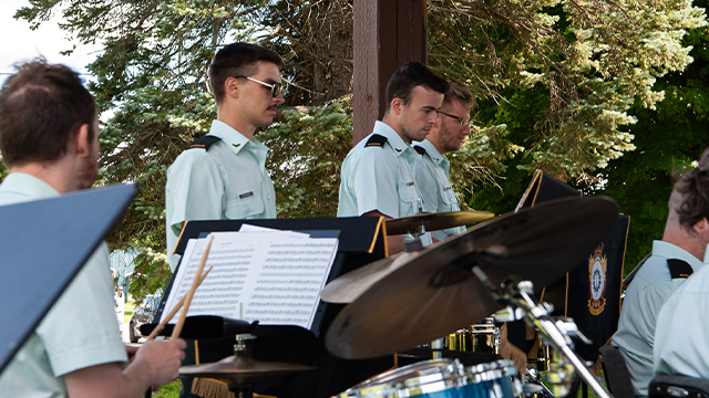Les membres de l’orchestre de l’École de leadership et de recrues des Forces canadiennes donnent un concert à l’extérieur du lieu historique national de Coteau-du-Lac.