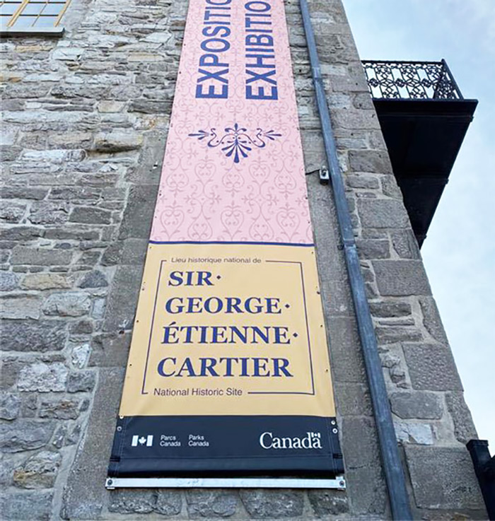 Banderolles d'une expositions sur la façade du lieu historique national de Sir-George-Étienne-Cartier.