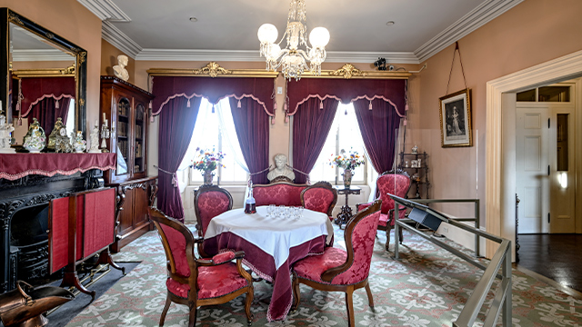 small salon at Sir George-Étienne Cartier National Historic Site, featuring a loveseat, two armchairs and several other pieces of furniture and objects that belonged to Sir George-Étienne Cartier.