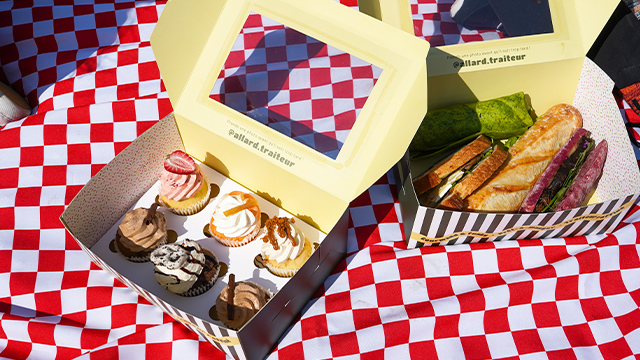 Cupcakes and a sandwich presented in cute boxes and prepared by Allard Traiteur.